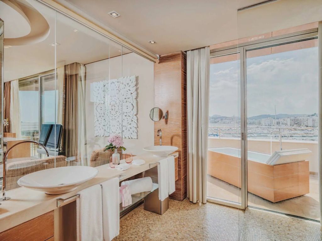 Modernes Badezimmer mit Waschtisch und Zugang zu einer Terrasse mit Poolblick