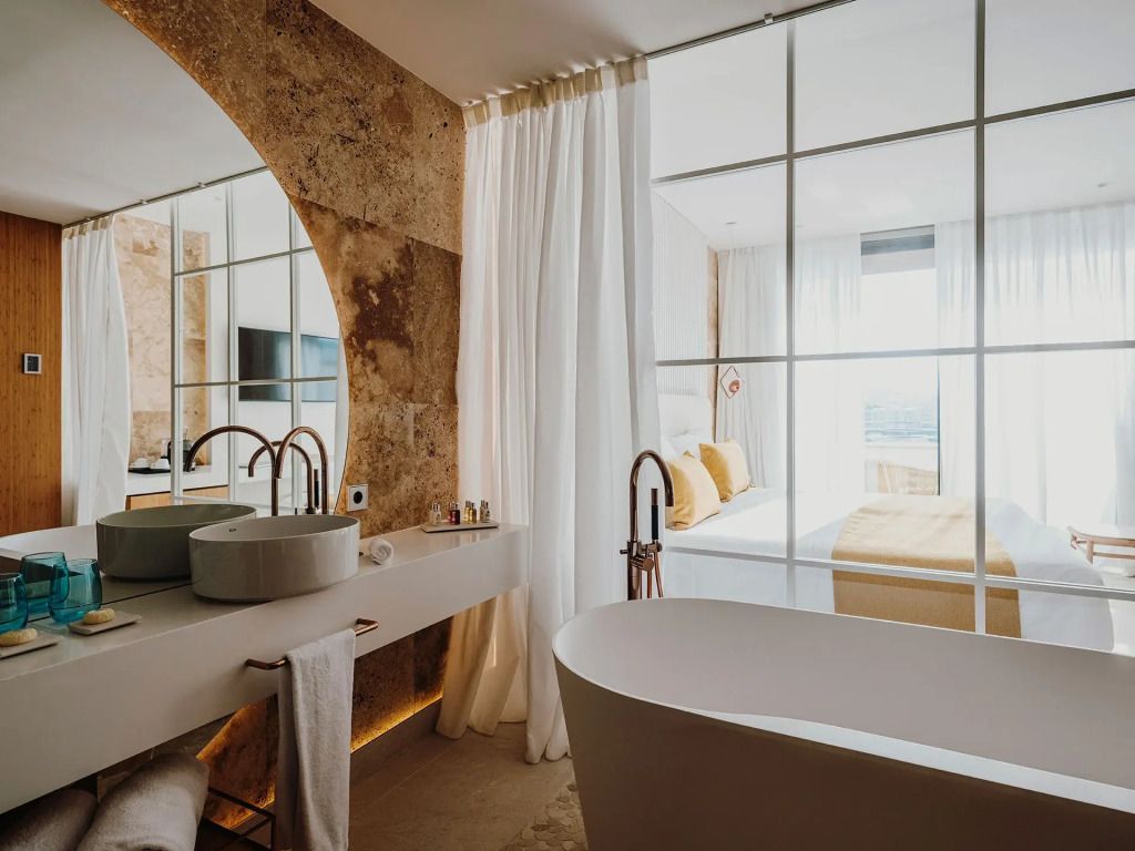 Modernes Badezimmer mit freistehender Badewanne und Sicht ins Schlafzimmer