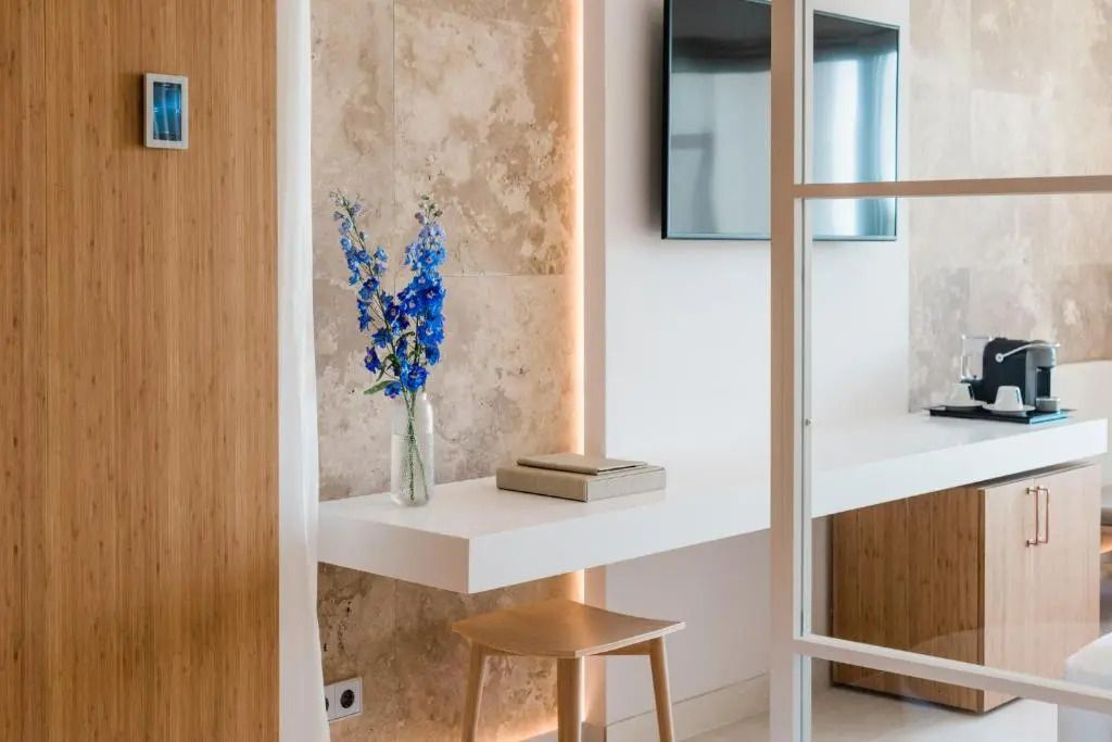 Flur mit Esstisch, blauen Blumen und moderner Wandgestaltung im Hotelzimmer