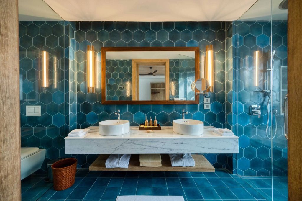 Luxuriöses Badezimmer mit Doppelwaschbecken und blauen Fliesen