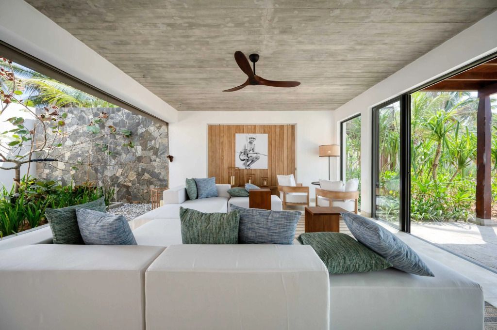 Moderne Lounge mit großen Fenstern und Blick auf die Natur in einer Suite