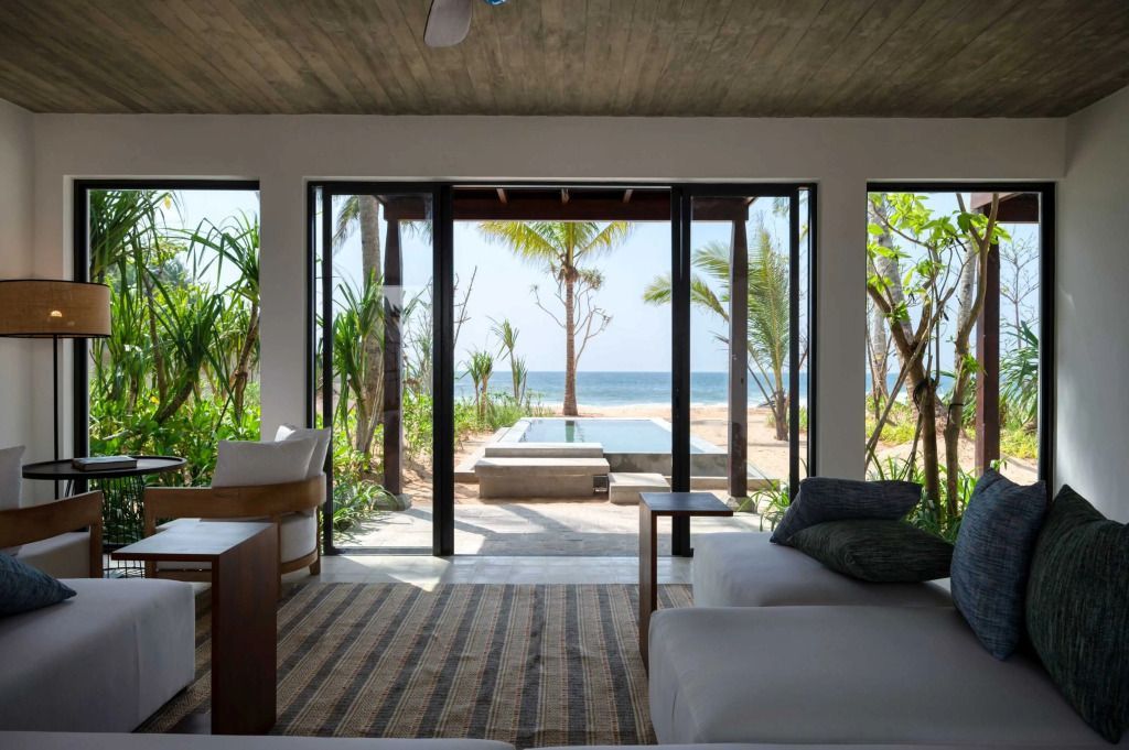 Suite mit großem Fenster und Blick auf Pool und Meer