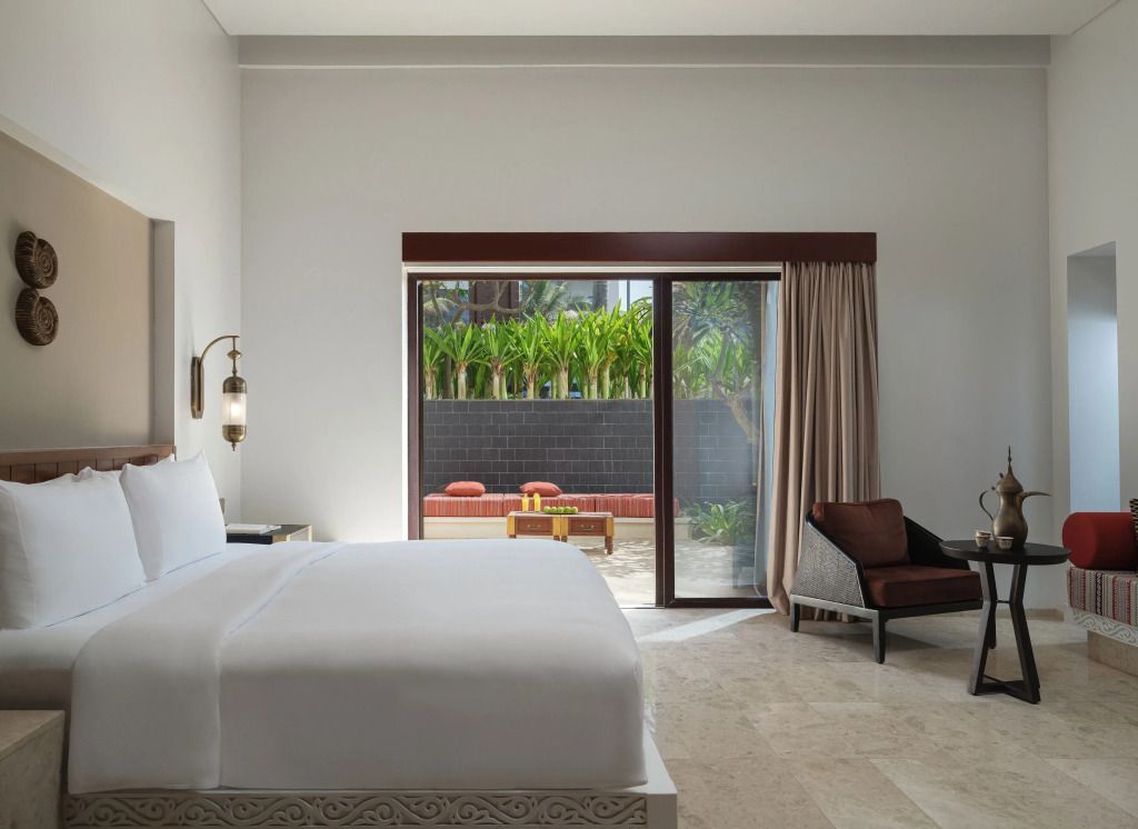 Moderne Junior-Suite mit Doppelbett und Zugang zur Terrasse im Al Baleed Resort Salalah