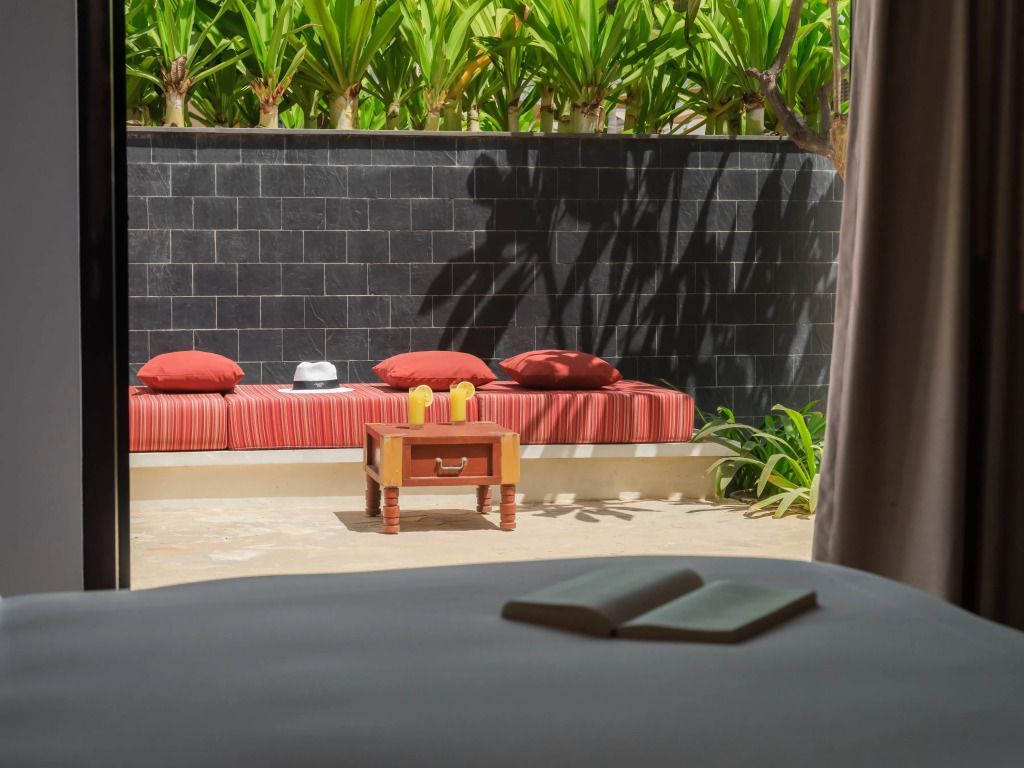 Traumhafte Terrasse mit gemütlicher Sitzgelegenheit vor tropischen Pflanzen im Al Baleed Resort