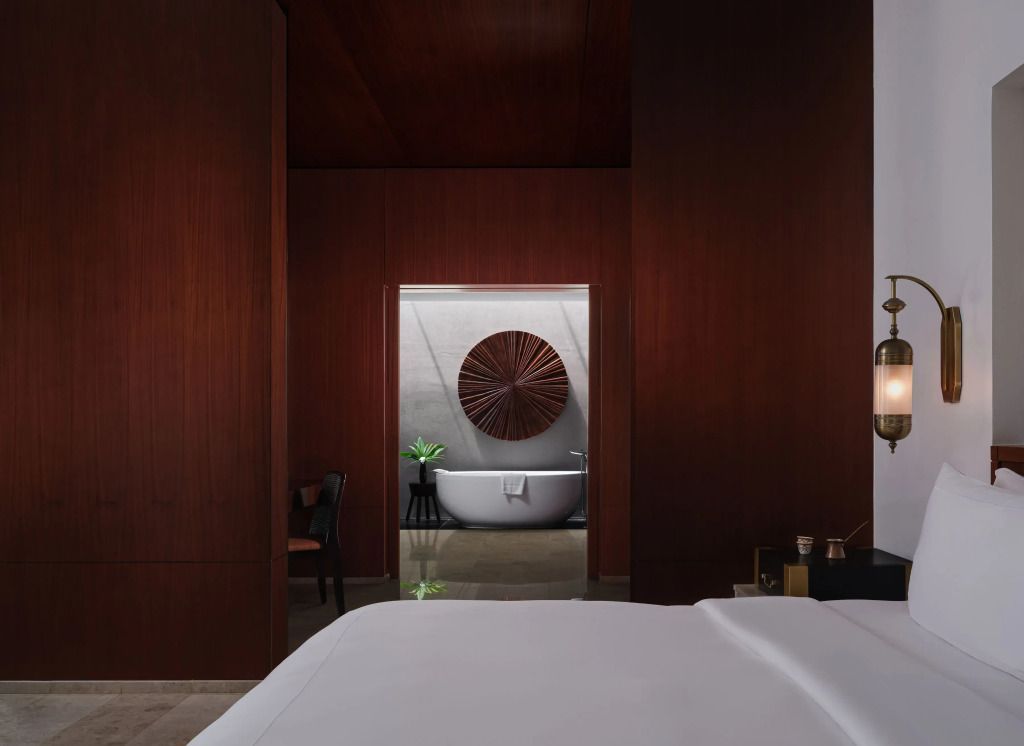 Luxuriöses Badezimmer mit freistehender Badewanne und Holzwand-Details im Al Baleed Resort