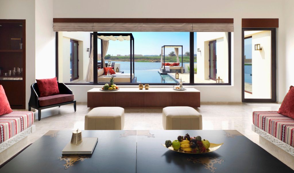 Offener Wohnbereich mit Blick auf den Infinity Pool und Garten