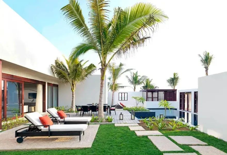 Gepflegter Garten und Terrasse mit Liegen bei einer Villa