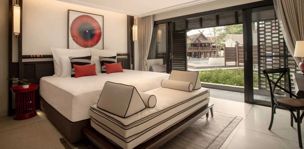 Deluxe Zimmer mit großem Bett, eleganter Tagesliege und Blick auf den Garten