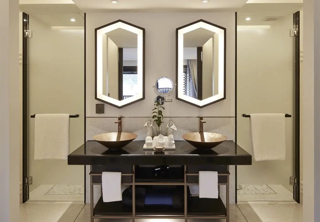 Modernes Badezimmer mit zwei Waschbecken und beleuchteten Spiegeln