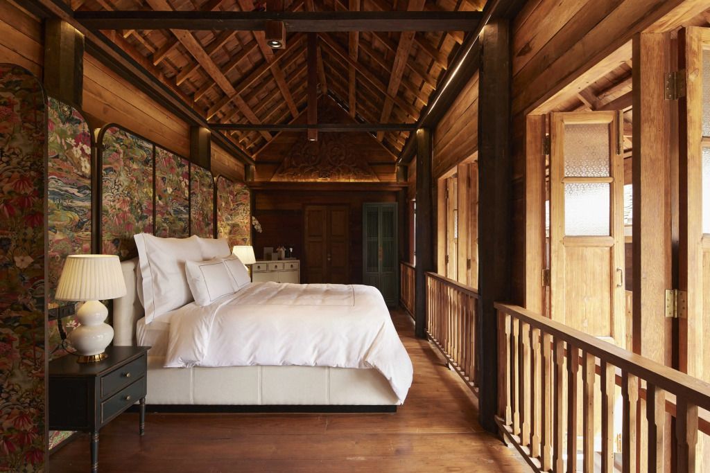 Holzverkleidetes Schlafzimmer mit Balkon und Himmelbett