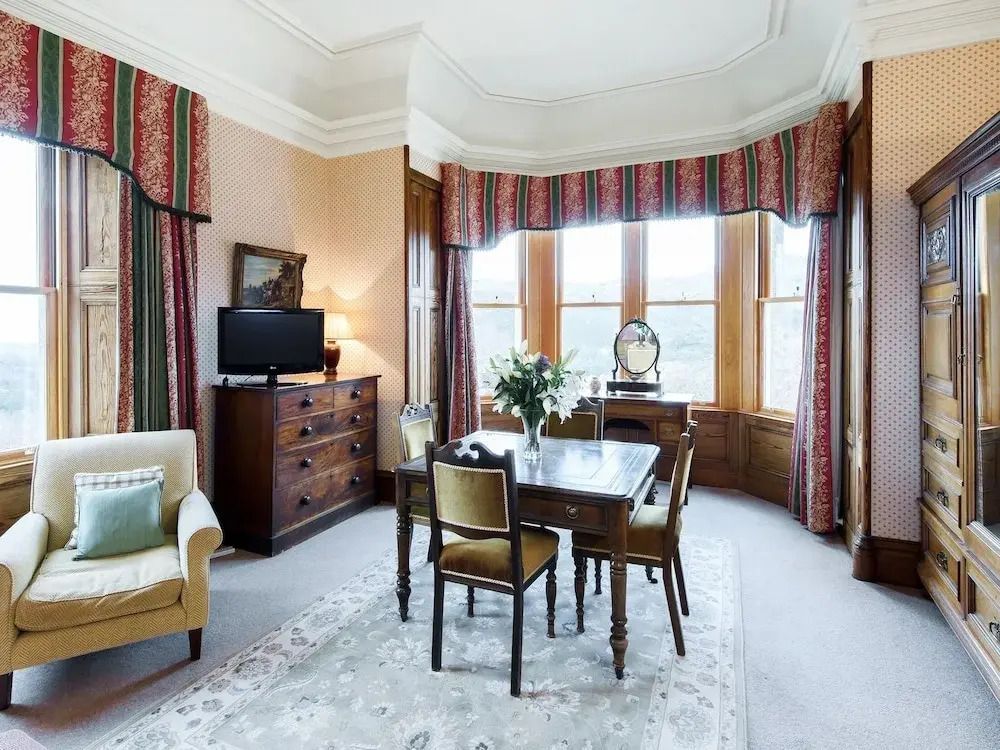 Elegante Sitzecke in einem hellen Zimmer mit klassischen Möbeln und weitem Bergblick