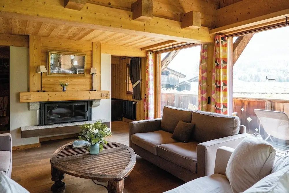 Wohnbereich mit Kamin und bequemen Sofas aus Holz in heller Atmosphäre