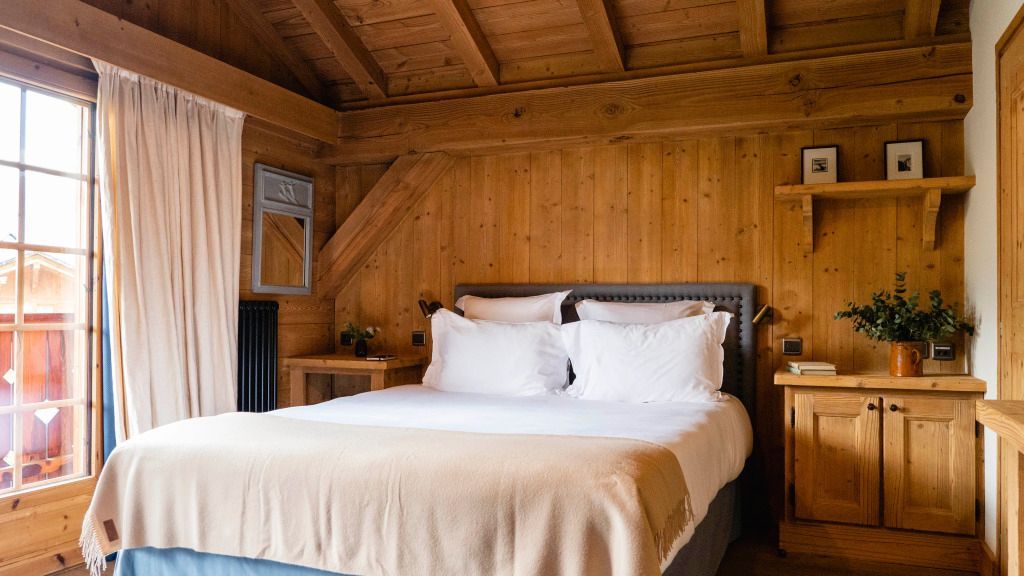Rustikales Schlafzimmer mit Holzwänden und luxuriösem Bett