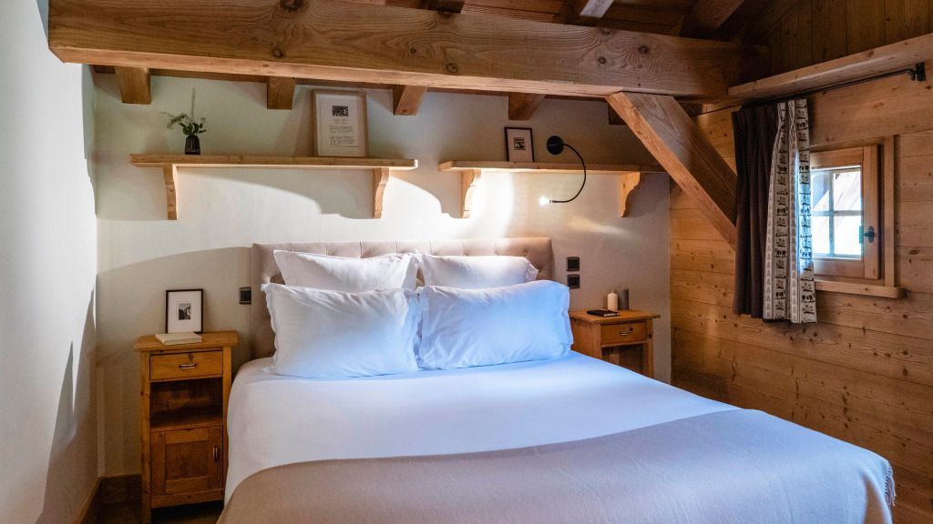 Schlafzimmer im Chalet-Stil mit Holzbalken und weichen Kissen