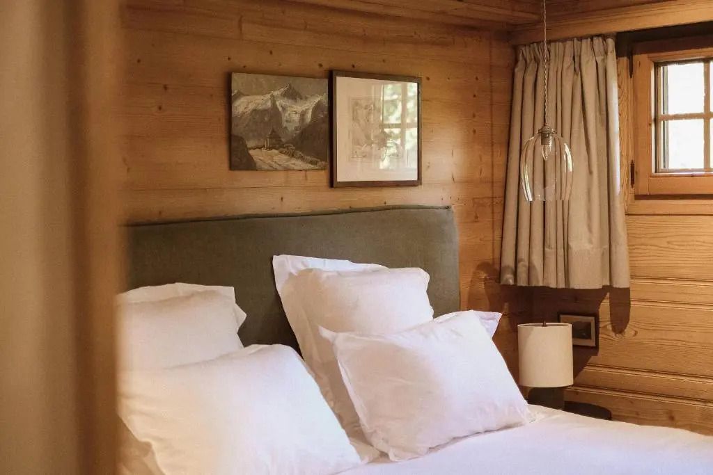 Gemütliches Schlafzimmer mit Holzverkleidung und modernen Lampen