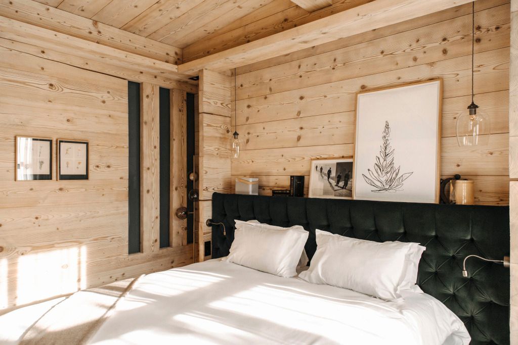Gemütliches Klassikzimmer mit Holzwänden und stilvollem Bett