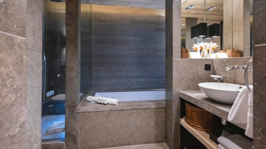 Luxuriöses Badezimmer mit Badewanne und Steinverkleidung