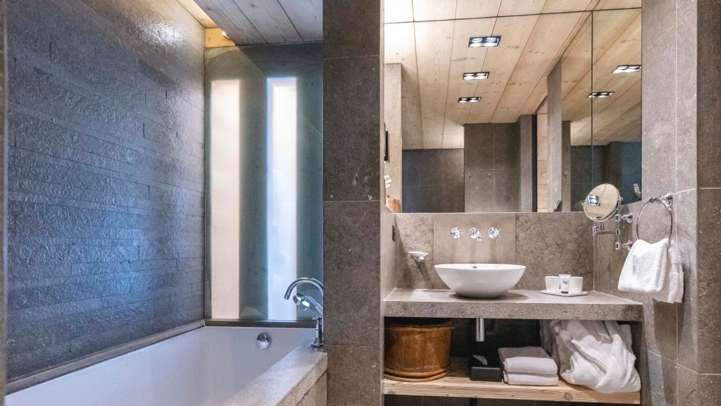 Modernes Badezimmer mit stilvollen Steinwänden und freistehendem Waschbecken