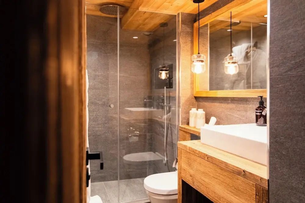 Modernes Badezimmer mit Glasdusche und Holzdetails im Luxus-Chalet.