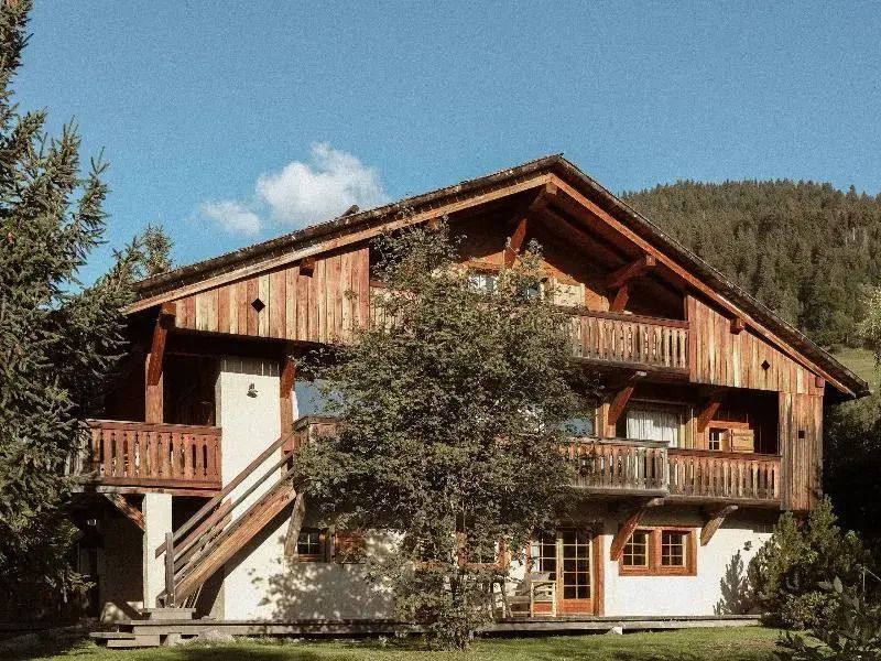 Rustikales alpines Chalet mit Holzbalkonen umgeben von Natur