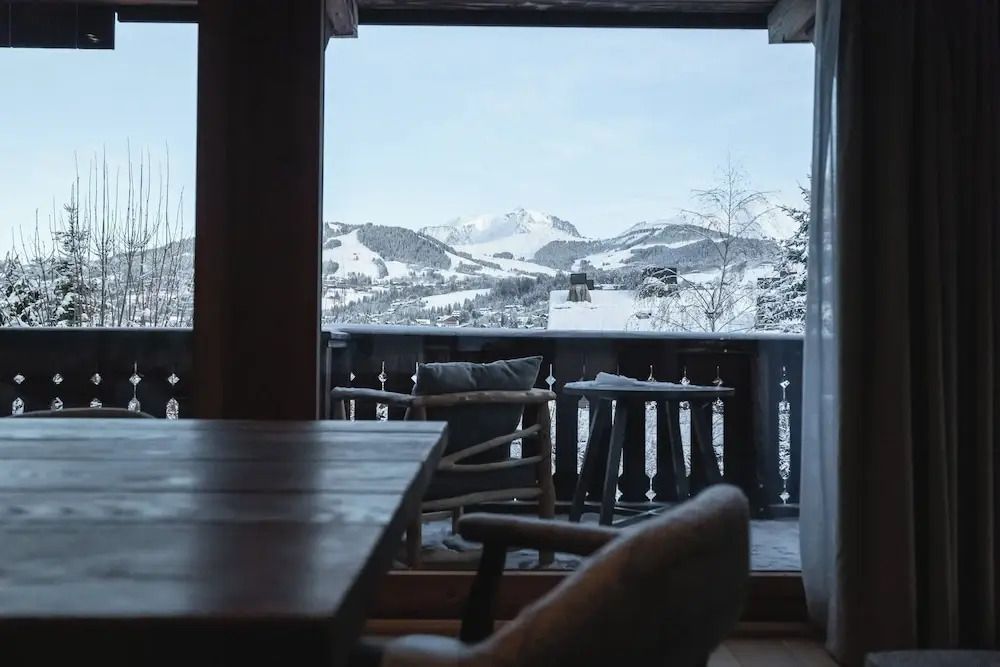 Blick von einem Balkon auf verschneite Berge und Tal