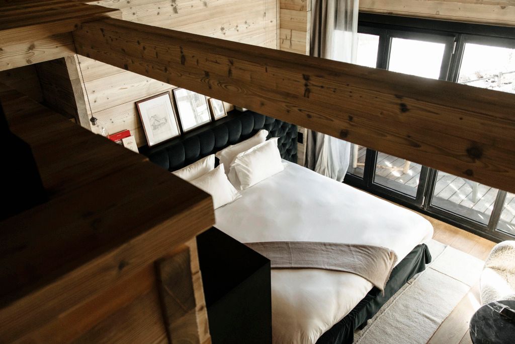 Gemütliches Schlafzimmer im Prestige-Zimmer mit Dachfenster und Holzbalken.