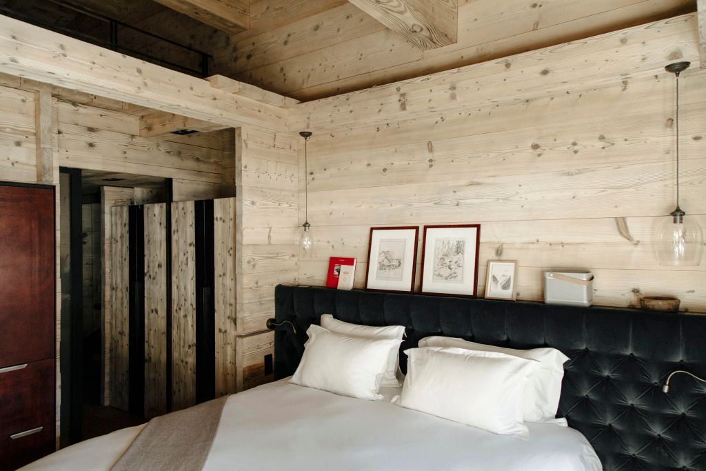 Zimmereinrichtung im alpinen Stil mit rustikalen Holzwänden und stilvollen Kunstwerken.