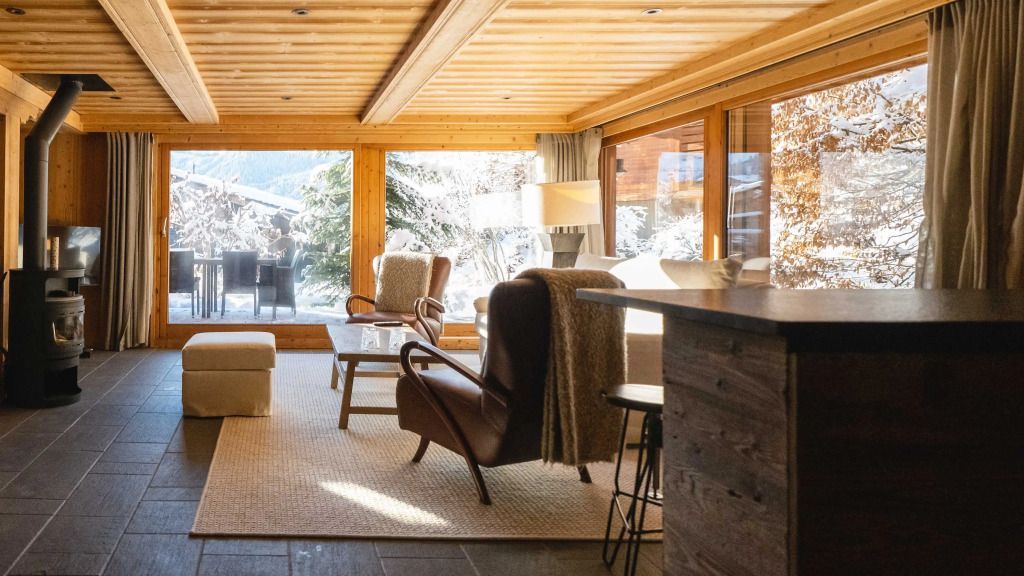 Eleganter Wohnbereich mit großen Fenstern und gemütlichen Sesseln