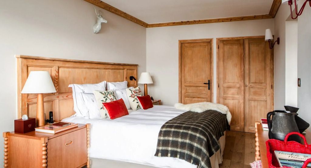 Gemütliches Schlafzimmer mit Doppelbett und Holzdetails in der Deluxe Suite