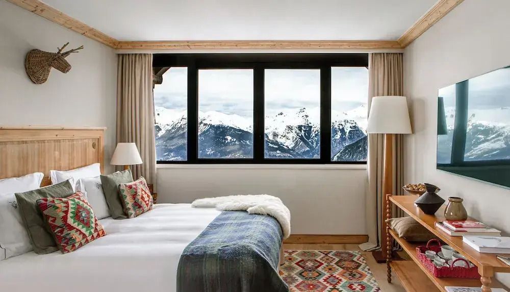 Deluxe Doppelzimmer mit Panoramablick auf verschneite Berge und gemütlicher Einrichtung