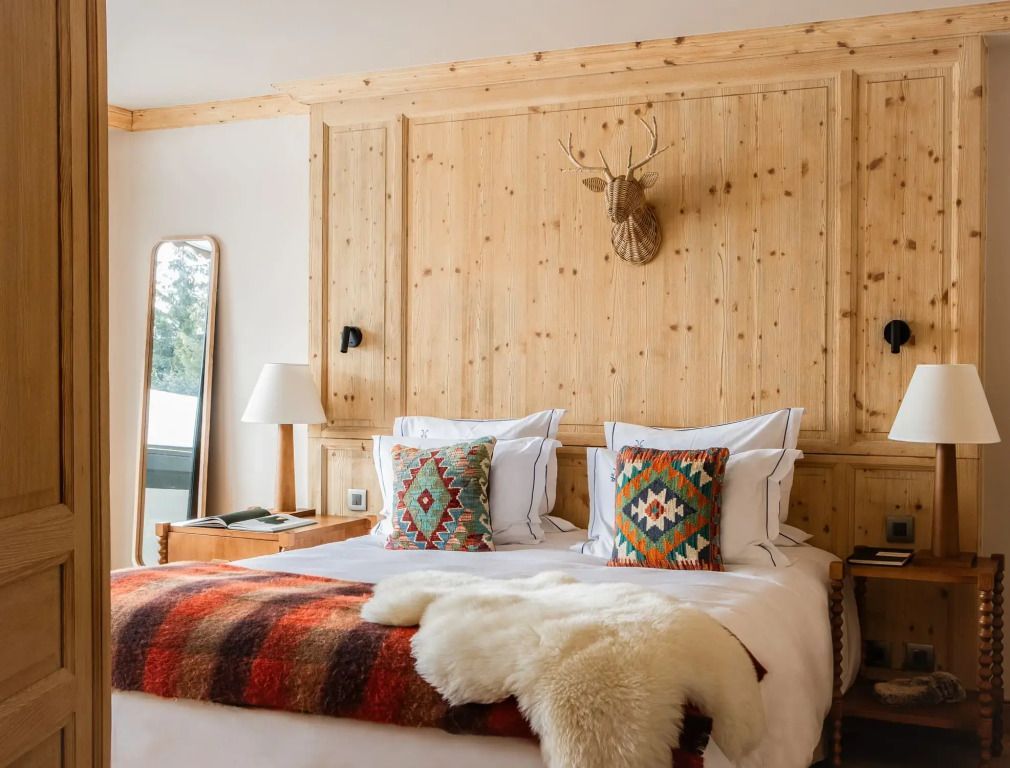 Gemütliches Schlafzimmer mit Holzwand und Hirschskulptur