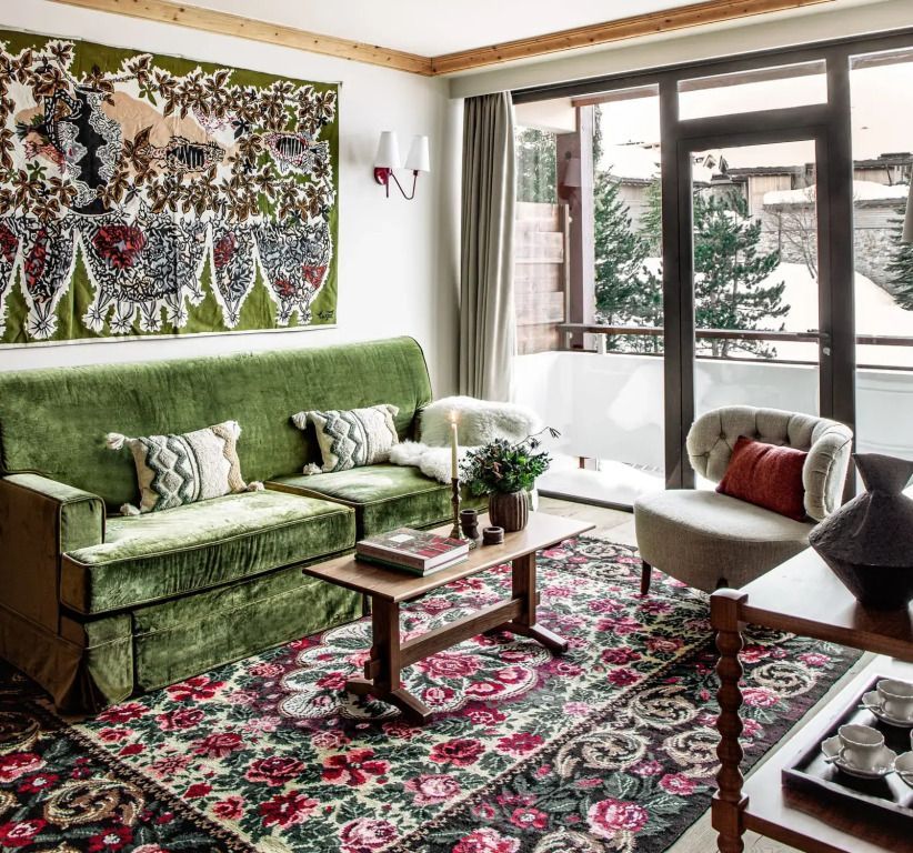 Wohnzimmer mit grünem Sofa und kunstvollem Wandteppich