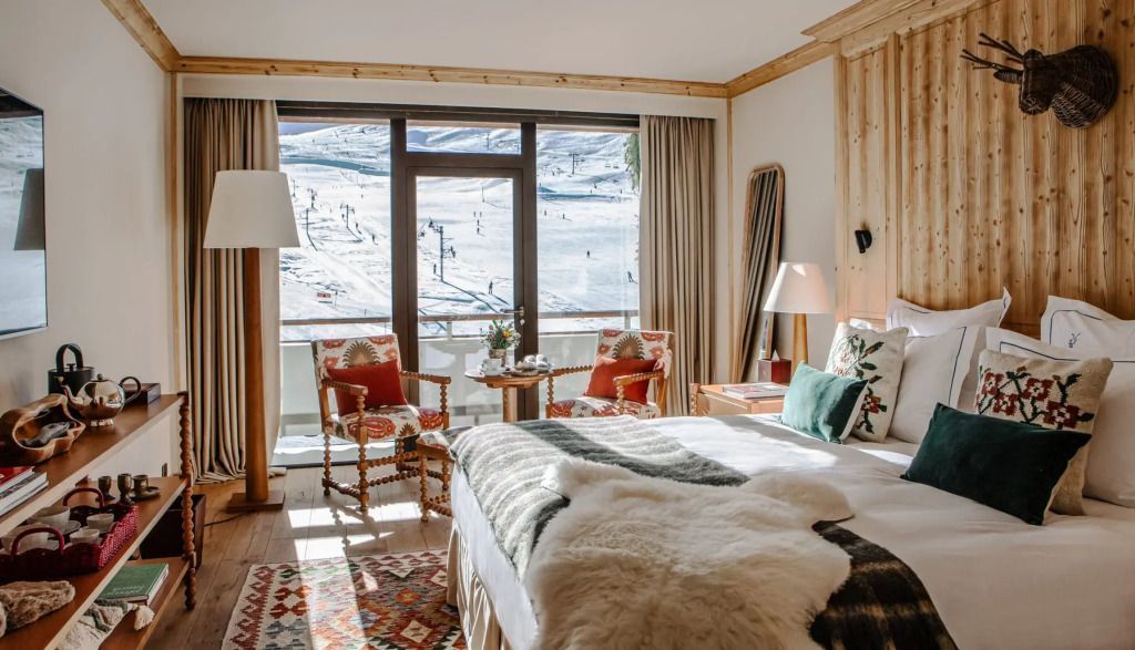 Zimmer mit großem Fenster und Blick auf schneebedeckte Berge