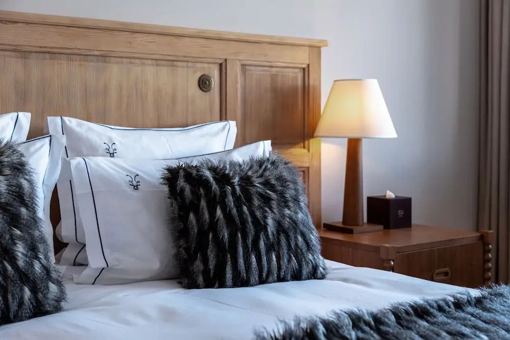Gemütliches Bett mit stilvollem Kissen und Lampe im Superior Doppelzimmer