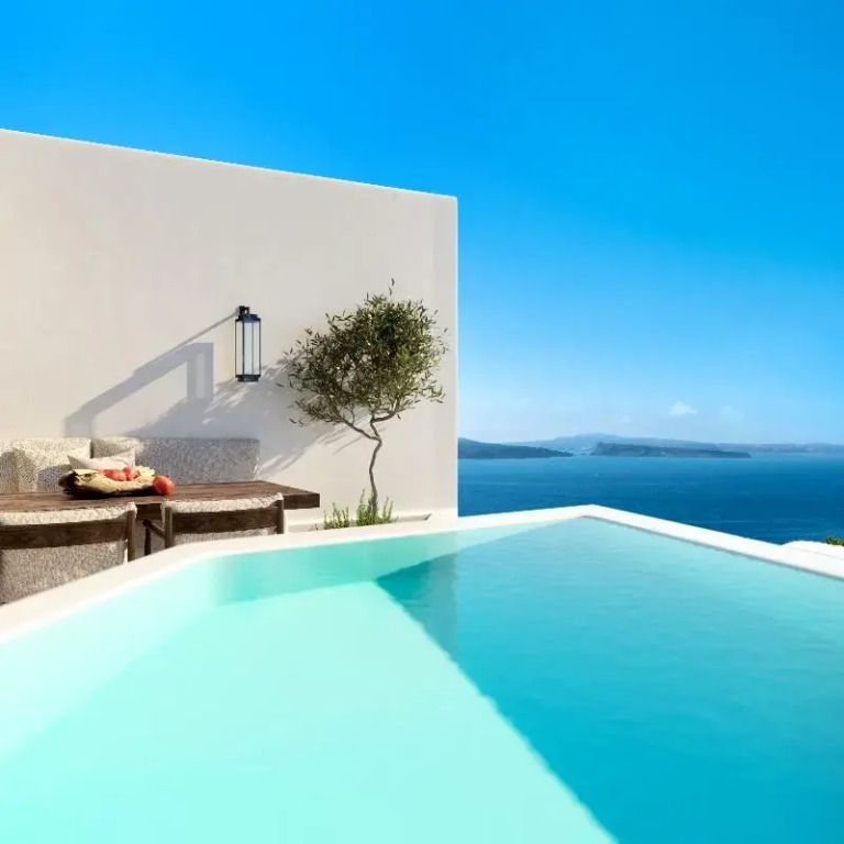 Infinity Pool mit Blick auf das Meer und die umliegenden Inseln bei klarem blauen Himmel