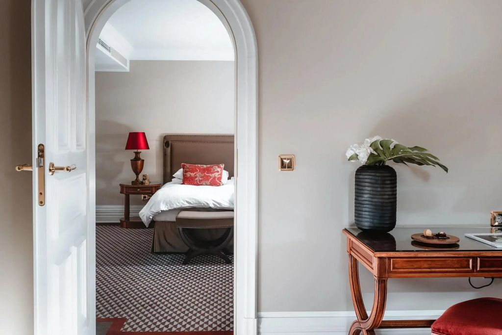 Elegante Suite mit Blick durch einen Bogen auf ein luxuriöses Doppelbett
