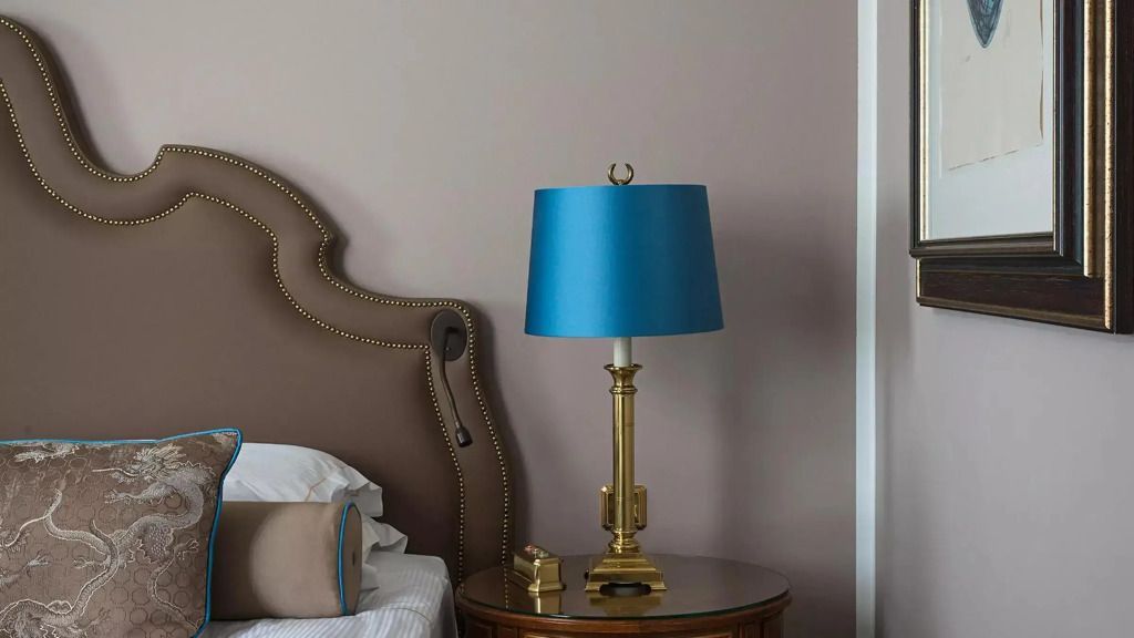Elegante Nachttischlampe auf edlem Holztisch mit luxuriösem Bettkopf