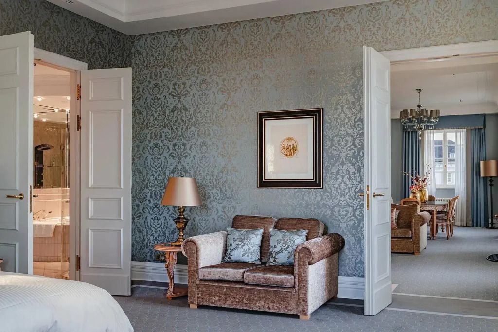 Gemütliche Sitzecke in der Suite mit elegantem Sofa und stilvoller Wanddekoration.