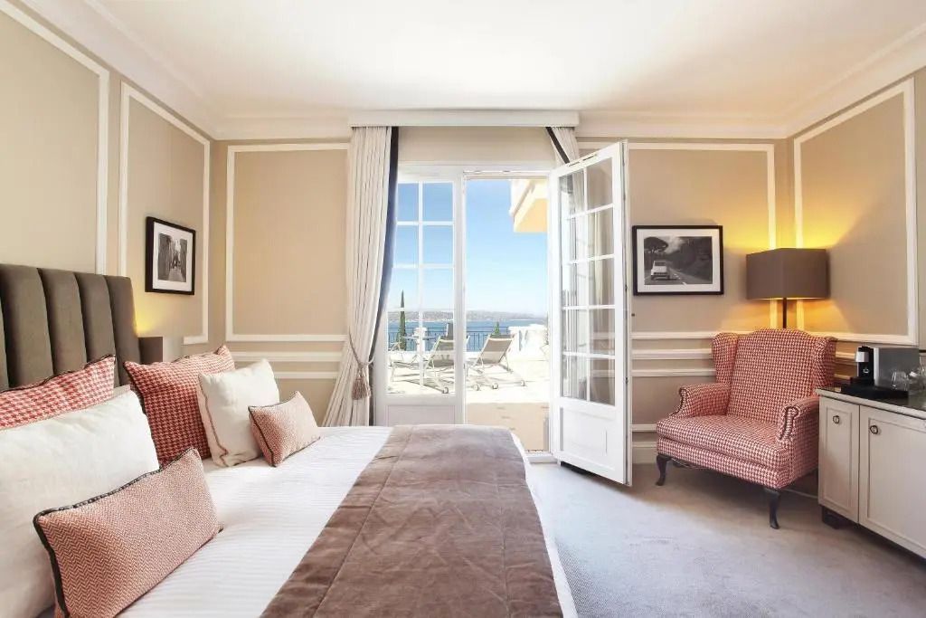 Hell eingerichtetes Doppelzimmer mit Meerblick und Zugang zum Balkon