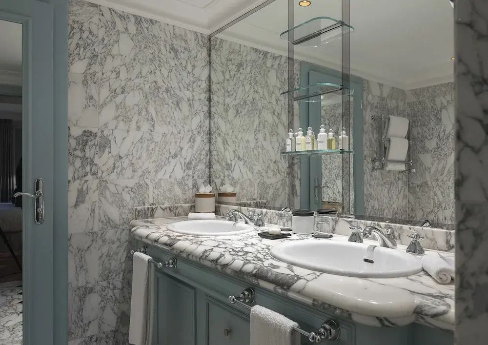 Luxuriöses Badezimmer mit zwei Waschtischen und marmorierten Wänden