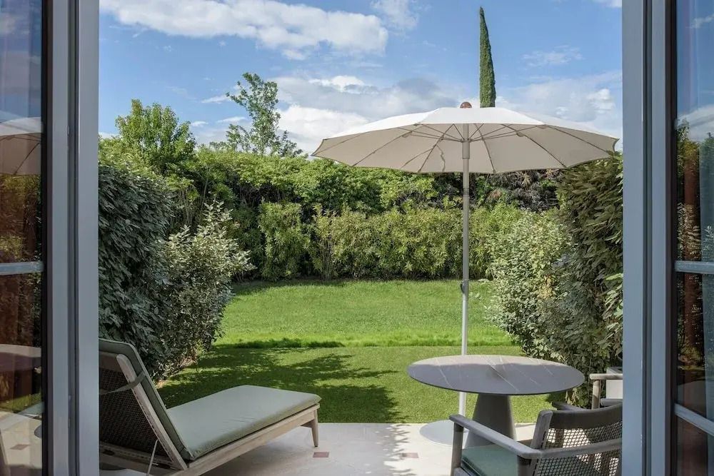 Privater Gartenbereich mit Sonnenliegen und Sonnenschirm vor dem Zimmer