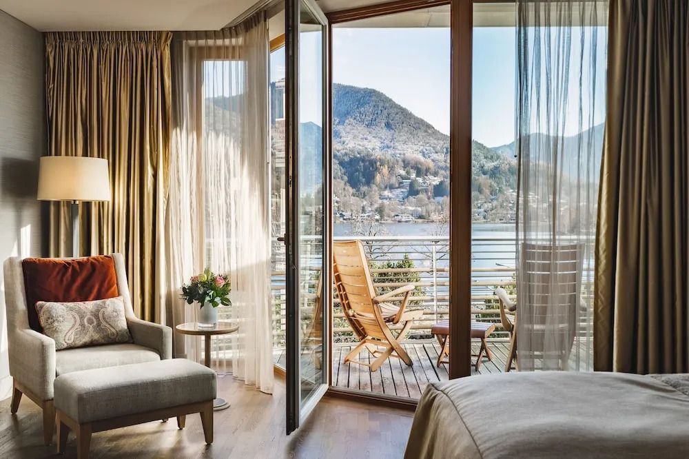 Deluxe Zimmer mit stilvoller Einrichtung und Seeblick vom Balkon.