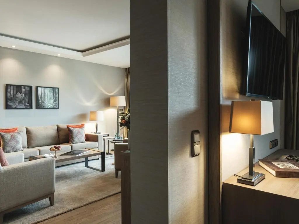 Elegantes Wohnzimmer in einer Hotelsuite mit gemütlichem Sofa und warmem Licht.