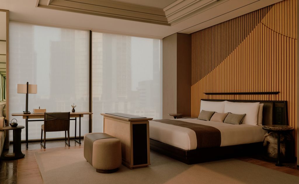 Moderne Suite mit Doppelbett und Schreibtischbereich mit großem Fenster