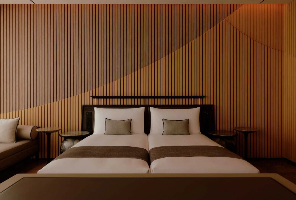 Elegante Twin-Bett-Suite mit stilvoller Holzvertäfelung und moderner Beleuchtung