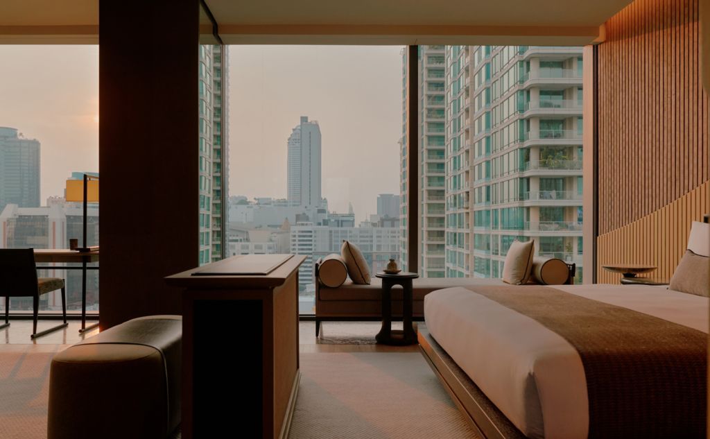Geräumiges Hotelzimmer mit Doppelbett und Blick auf die Skyline von Bangkok.