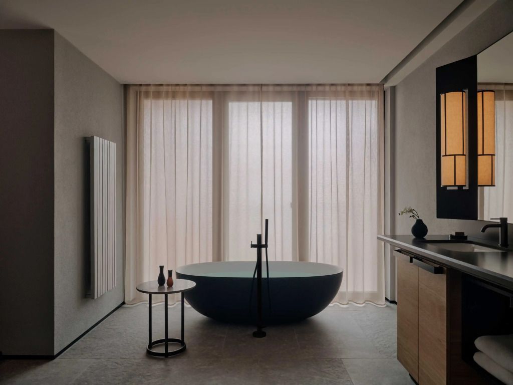 Stilvolles Badezimmer mit freistehender Badewanne und großen Fenstern