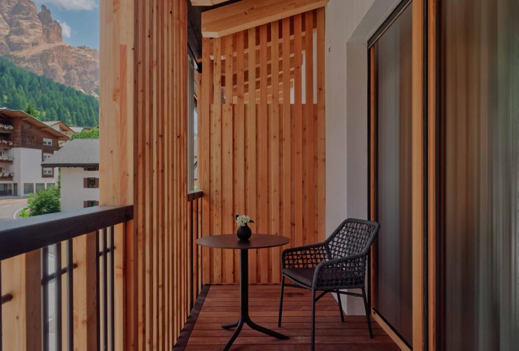 Balkon mit Holzelementen Tisch und Stuhl mit Bergblick