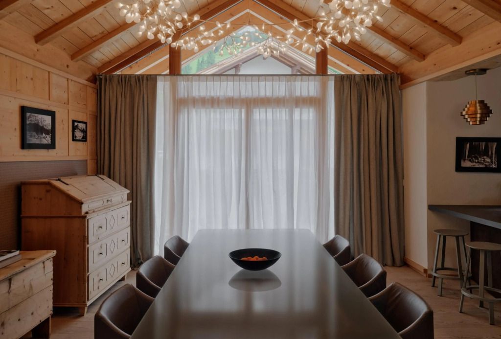 Esszimmer mit modernem Tisch und eleganten Deckenleuchten im Aman Rosa Alpina