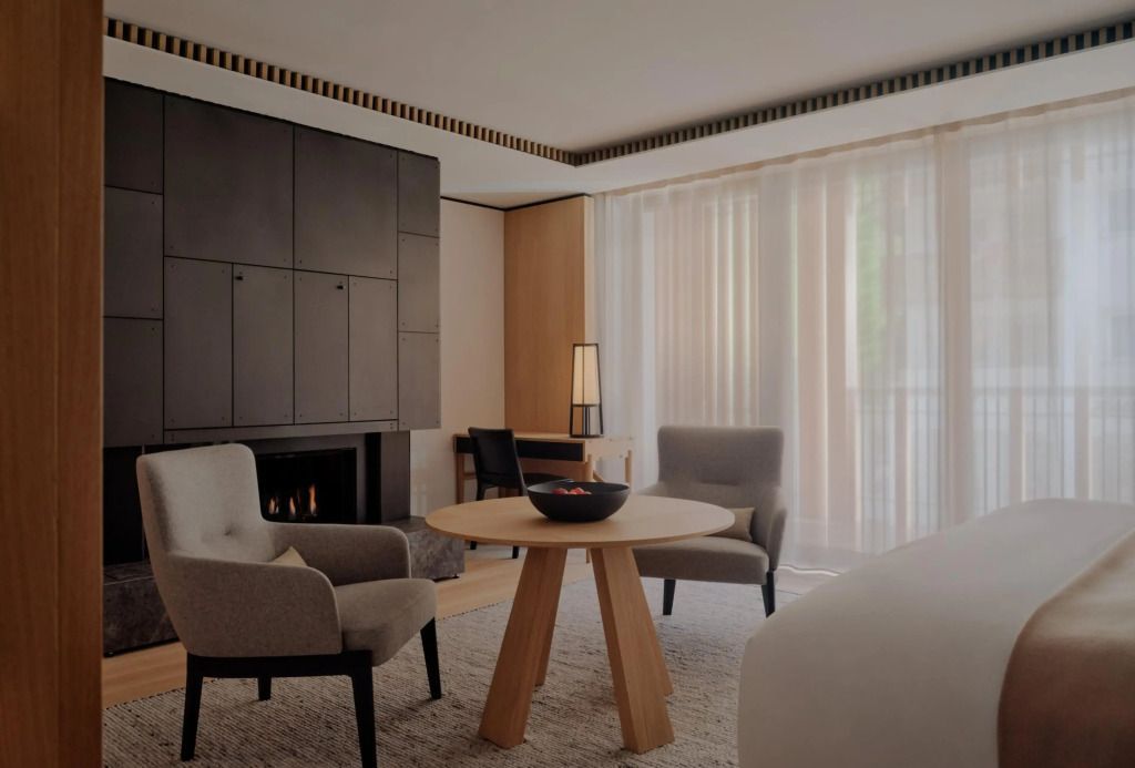 Gemütlicher Sitzbereich im Hotelzimmer mit Kamin und modernem Design